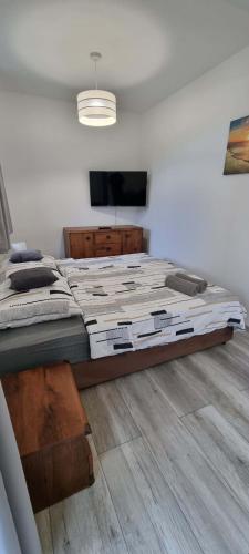 a large bed in a room with a television at Willa North Star in Władysławowo