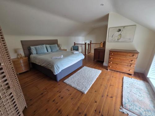 a bedroom with a bed and a wooden floor at The Old Milking Parlour at Knapp Farm in Dorchester
