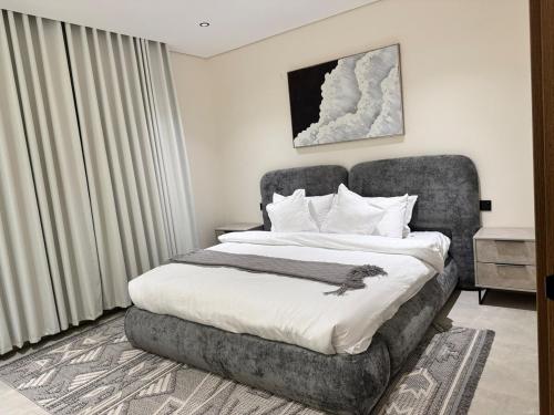 a bedroom with a large bed with a gray chair at سويت مسك غرفة وصالة بلمسة عصرية راقية in Dammam