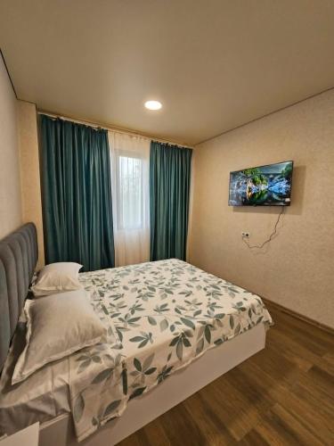 a bedroom with a bed and a tv on the wall at Sun Estate Ureki in Ureki