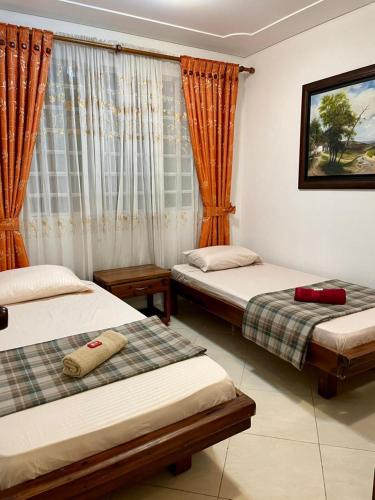 a bedroom with two beds and a window at La finca de dulce in Silvania