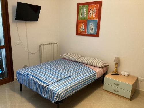 a bedroom with a bed and a tv on the wall at Le Persiane Azzurre ovest in Albiano