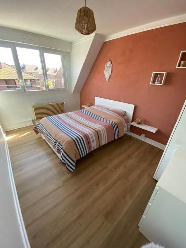 a bedroom with a bed in the corner of a room at Maison cosy Dunkerque in Dunkerque