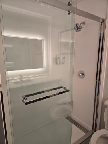 a bathroom with a shower with a glass door at Rodeway Inn in Portage