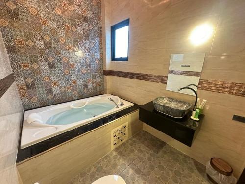 a bathroom with a tub and a toilet and a sink at Boonfarm&homestay in Ban Nop Hak