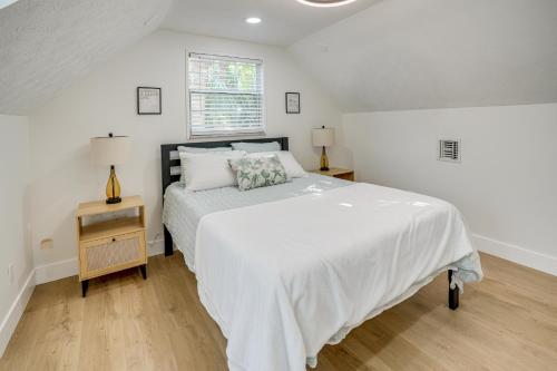 a white bedroom with a large bed and a window at Deck + Pool Table! Walk to Dtwn Jensen Beach in Jensen Beach