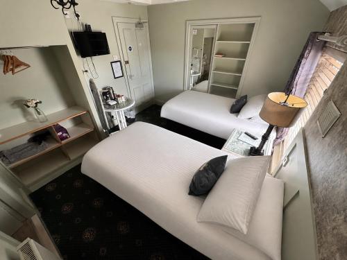 a hotel room with two beds and a television at Holland Hotel in Llanfachraeth