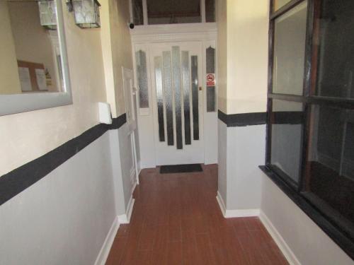 a hallway with a white door and a wooden floor at No Twelve in Blackpool