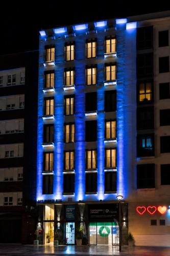 a lit up building with blue lights on it at Apartamentos Turísticos Puerta Real by CartagenaSpain in Cartagena