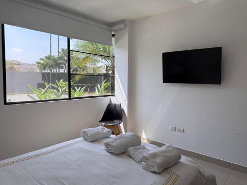 a bedroom with a bed with a flat screen tv at Nice and Modern Apartment, Parking in SamborondÃ³n