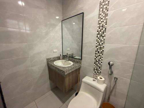 a bathroom with a toilet and a sink and a mirror at Nice and Modern Apartment, Parking in SamborondÃ³n