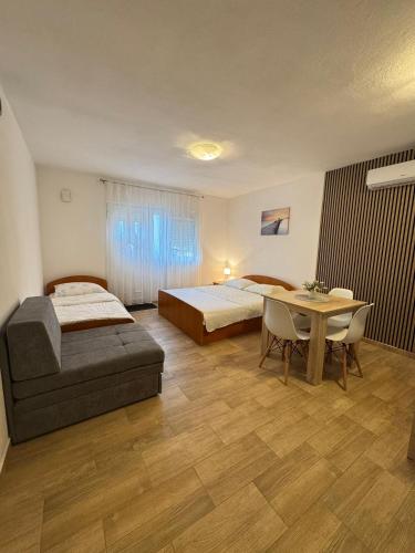 a hotel room with two beds and a table at Apartmani Frane in Neum