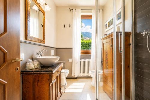 a bathroom with a sink and a toilet and a window at Villa Le Rose, Menaggio in Menaggio