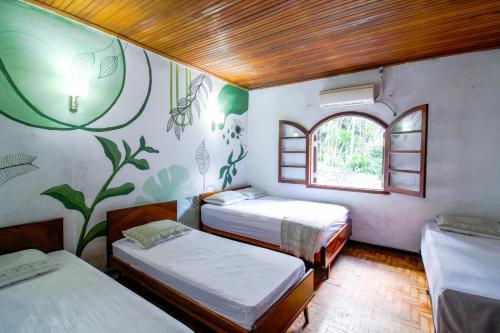 a room with three beds and a window at Sítio com Piscina Aquecida 7 Quartos com ar condicionado próximo de São Paulo in Juquitiba