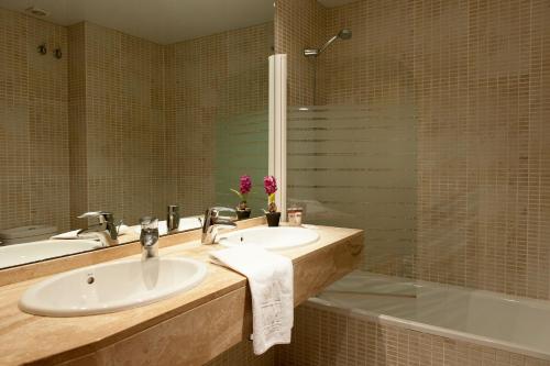 ein Badezimmer mit 2 Waschbecken und einer Badewanne in der Unterkunft MH Apartments Gracia in Barcelona