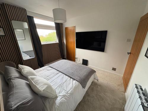 a bedroom with a bed and a flat screen tv at Ravelston in Edinburgh
