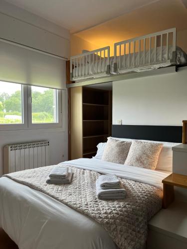 a bedroom with a bed with two towels on it at Casa Xoubiña in Mos