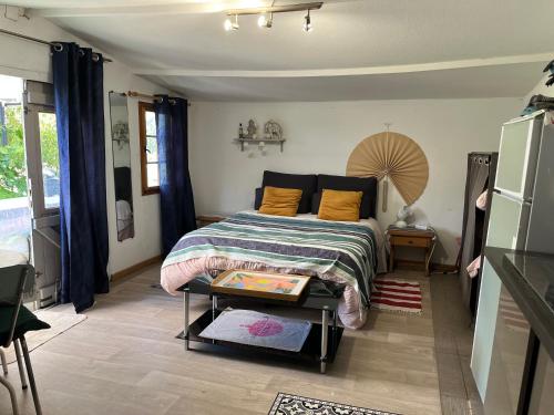 a bedroom with a bed and a table in it at Chalet des oliviers 10mn CV Béziers dans propriété bien pour cyclistes in Béziers