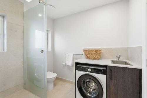 a bathroom with a washing machine and a sink at Designer Stay with River Views) in Sandy Bay