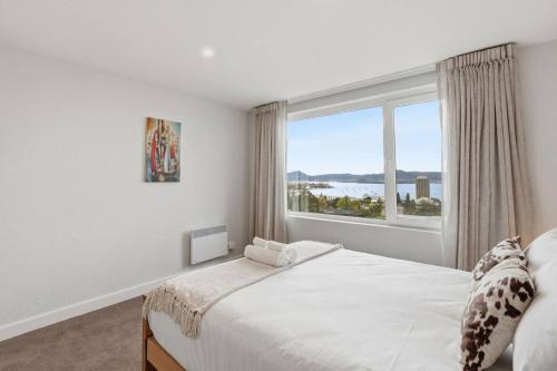 a bedroom with a bed and a large window at Designer Stay with River Views) in Sandy Bay