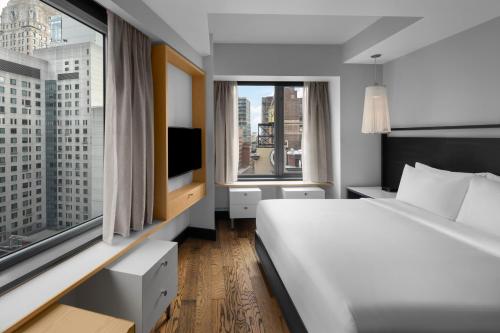 a bedroom with a white bed and a large window at Hyatt Union Square New York in New York