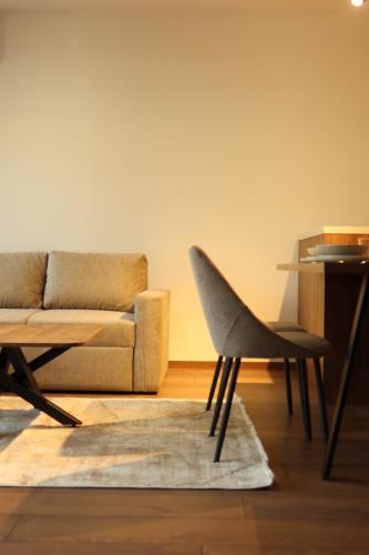 a living room with a couch and a chair at NUMA LIVING - Executive Suite in Kumanovo