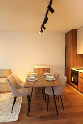 a dining room with a wooden table and chairs at NUMA LIVING - Executive Suite in Kumanovo