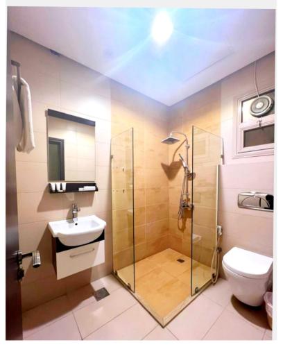 a bathroom with a shower and a toilet and a sink at Dahlia Hotel Apartment Riggae in Kuwait