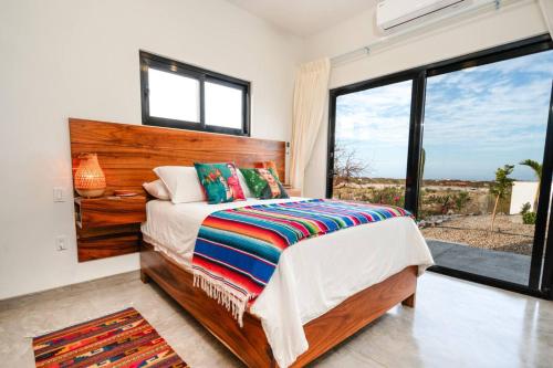 a bedroom with a bed and a large window at Montebello Pool House-3 BD in Los Barriles