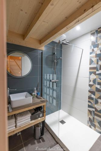 a bathroom with a shower with a sink and a mirror at Aux Buis Gourmands in La Chapelle-en-Vercors