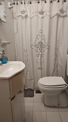 a bathroom with a toilet and a shower curtain at El Refugio in La Falda