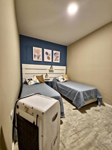 a bedroom with two beds and a television in it at El Refugio in La Falda