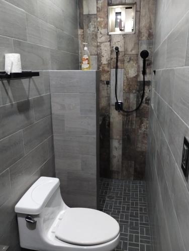 a bathroom with a shower and a toilet in it at Casa Rota in Mérida