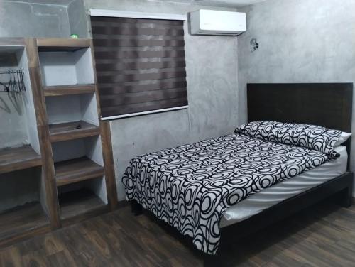 a bedroom with a bed and a book shelf at Casa Rota in Mérida