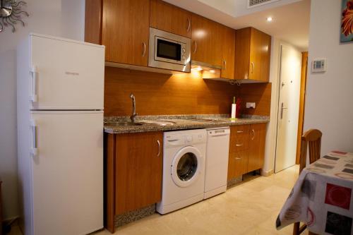 cocina con nevera blanca y lavadora en Apartamento Los Patos, en Benalmádena