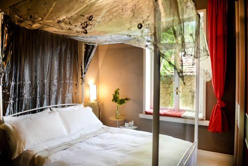 a bedroom with a canopy bed and a window at Maison de la Poupée in Afétai