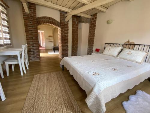 a bedroom with a large bed and a table and chairs at Fântânele Vacation Home, Charming Rustic Home in Fîntînele