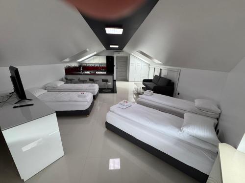 a room with three beds and a television in it at Motel Okoń in Orzysz