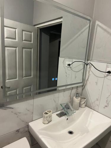 a bathroom with a white sink and a mirror at Odette Retreat in Braeton