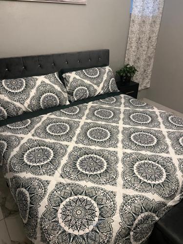 a bed with a black and white quilt on it at Odette Retreat in Braeton