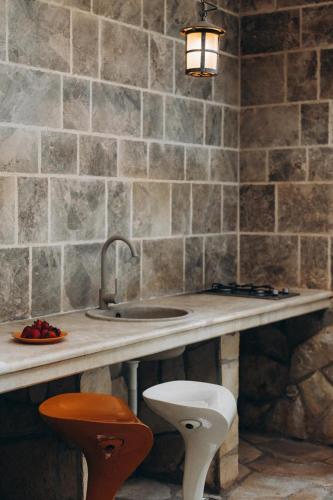 a kitchen with a counter with a sink and two stools at Carob Breeze House in Krimovice