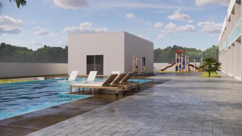 a swimming pool with lounge chairs next to a building at Costa Atlântico House in Garopaba