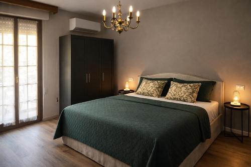 a bedroom with a green bed and a chandelier at Villa Alina Family Retreat in Pietrasanta