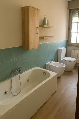 a bathroom with a bath tub and a toilet at Villa Alina Family Retreat in Pietrasanta