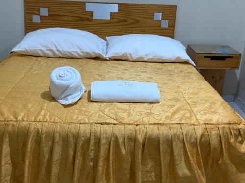 a bed with a towel and a hat on it at HOTEL SANTA BARBARA PUERTO ilo in Ilo