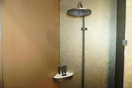 a bathroom with a shower with a toilet and a sink at Alsun Hotel in Astana