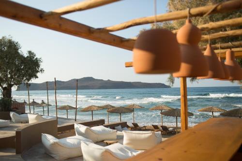 a view of the beach with chairs and umbrellas at The Theodore Boutique Hotel- adults only 16 plus in Agia Marina Nea Kydonias
