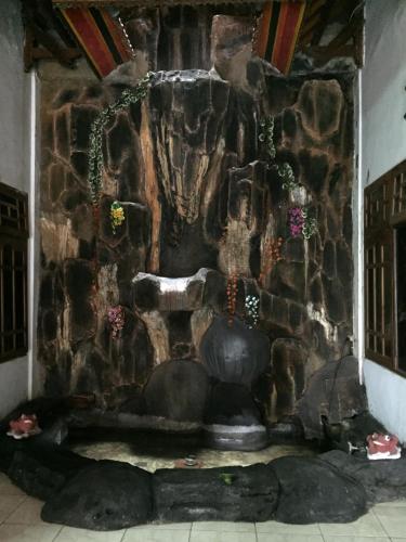a stone wall with a fountain in a room at Ratih Bali Hostel in Denpasar
