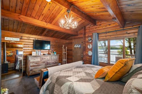 a bedroom with a bed and a television in a cabin at Mat-Su Resort in Wasilla