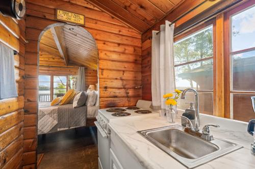 a kitchen in a log cabin with a sink at Mat-Su Resort in Wasilla
